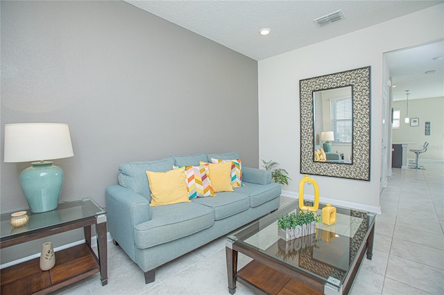 living room with light tile patterned flooring and a textured ceiling