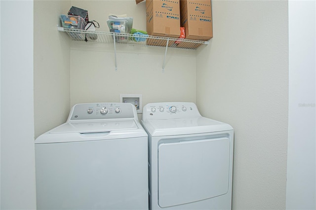 clothes washing area with washing machine and dryer