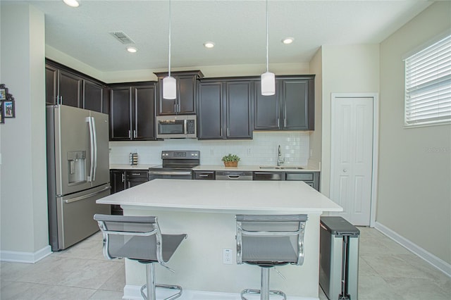 4708 Tribute Trl, Kissimmee, FL 34746 - kitchen featuring a sink, stainless steel appliances, a center island, a breakfast bar area, and visible vents