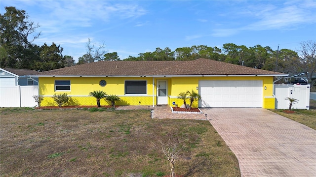 ranch-style home with a garage and a front yard