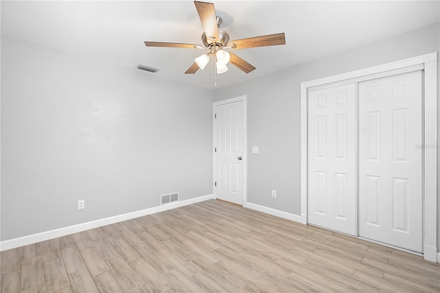 unfurnished bedroom with light hardwood / wood-style floors, a closet, and ceiling fan