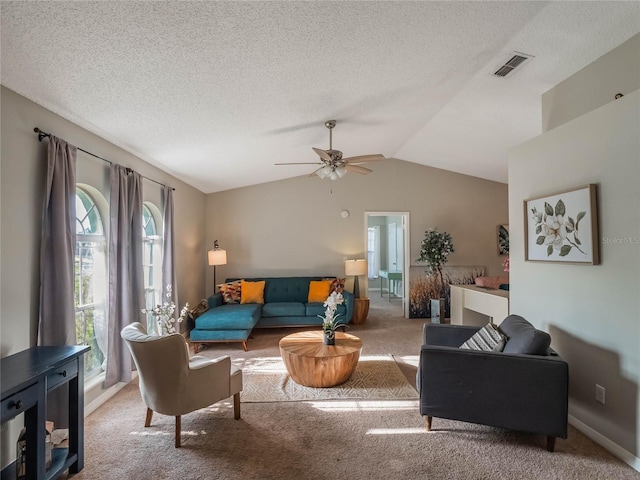 living room featuring ceiling fan, vaulted ceiling, a textured ceiling, and carpet