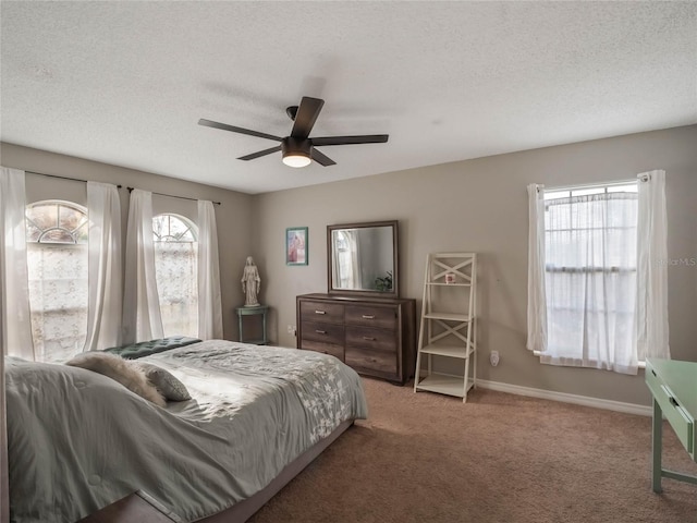 bedroom with ceiling fan, carpet floors, and a textured ceiling