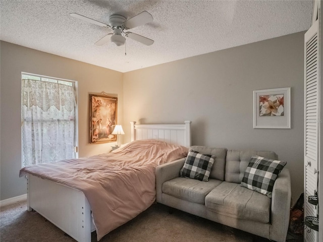 bedroom with ceiling fan, a textured ceiling, and dark carpet