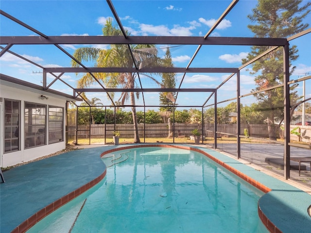 view of swimming pool featuring a lanai and a patio area