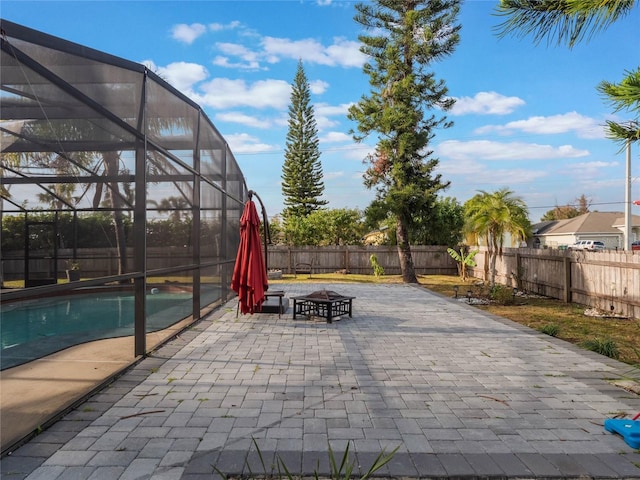 view of patio with a fenced in pool, an outdoor fire pit, and glass enclosure