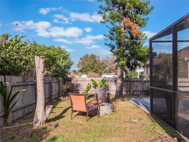 view of yard with glass enclosure and a fire pit