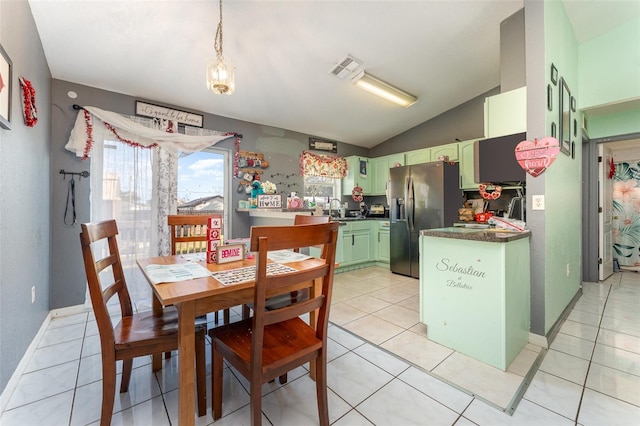 kitchen featuring green cabinets, stainless steel refrigerator with ice dispenser, light tile patterned flooring, vaulted ceiling, and kitchen peninsula