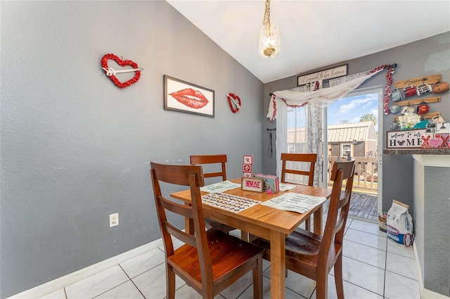 tiled dining space featuring lofted ceiling