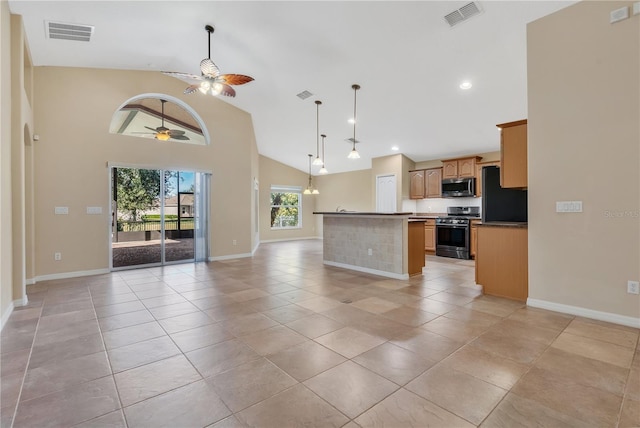 kitchen featuring a kitchen island, pendant lighting, light tile patterned floors, ceiling fan, and stainless steel appliances