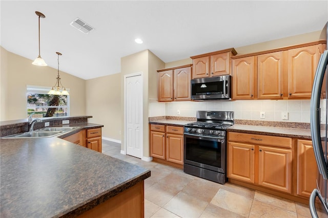 kitchen with lofted ceiling, sink, appliances with stainless steel finishes, backsplash, and hanging light fixtures