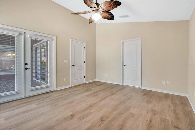 empty room featuring ceiling fan, high vaulted ceiling, and light hardwood / wood-style flooring