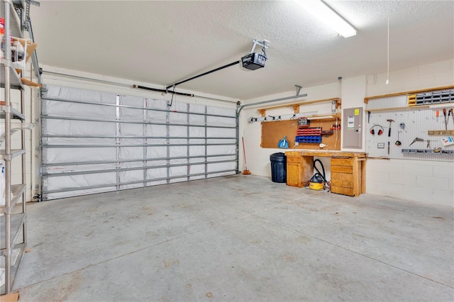 garage featuring a garage door opener, electric panel, and a workshop area