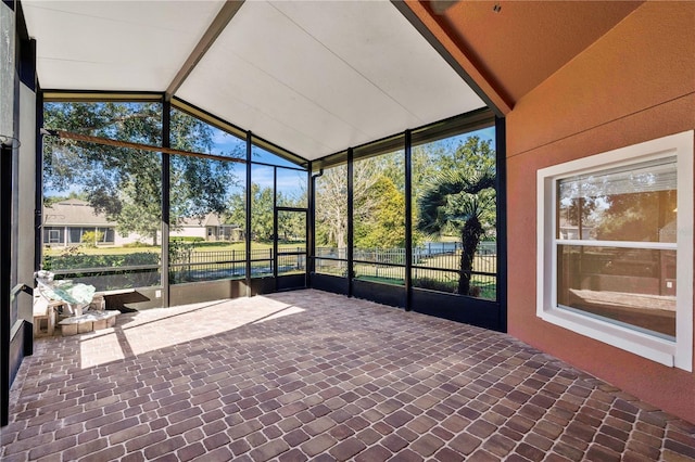 unfurnished sunroom featuring lofted ceiling