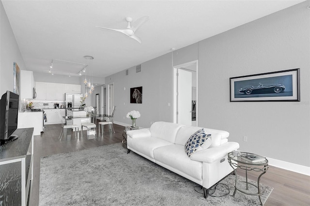 living room featuring hardwood / wood-style flooring, track lighting, and ceiling fan