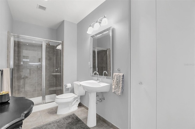 bathroom with an enclosed shower, tile patterned floors, and toilet