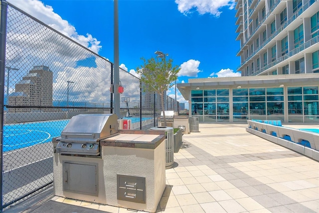 view of patio with area for grilling, basketball court, and grilling area