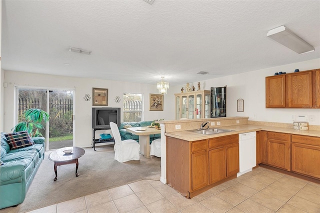 kitchen featuring sink, light carpet, a textured ceiling, kitchen peninsula, and dishwasher