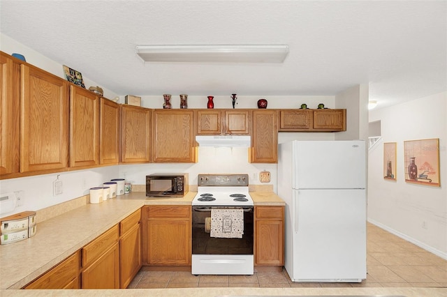 kitchen featuring white refrigerator, a textured ceiling, electric range oven, and light tile patterned floors