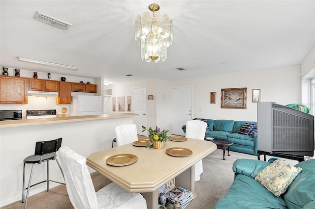 dining room featuring light colored carpet and a textured ceiling