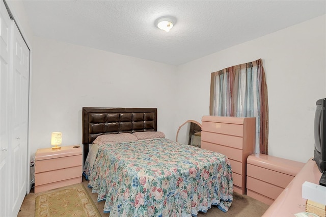 bedroom featuring light carpet, a closet, and a textured ceiling