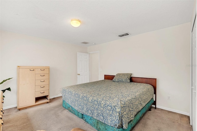 bedroom with carpet floors and a textured ceiling