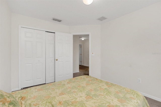 unfurnished bedroom with dark carpet and a closet