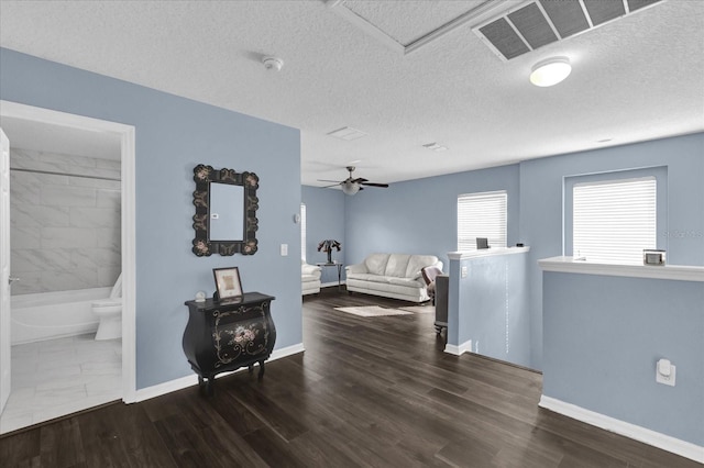 bedroom featuring connected bathroom, dark hardwood / wood-style flooring, and a textured ceiling