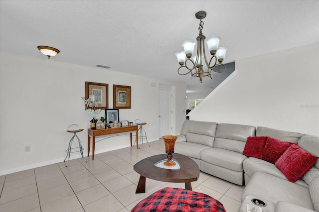 living room featuring a chandelier, light tile patterned floors, and a textured ceiling