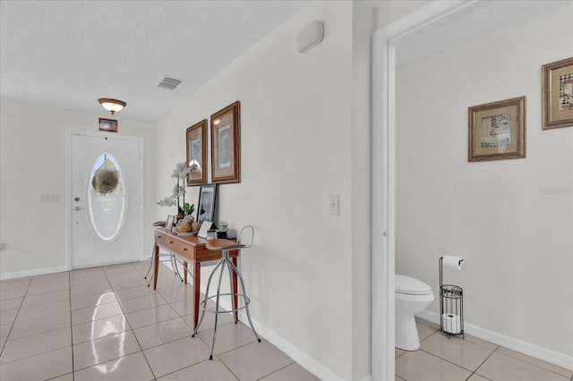 tiled foyer entrance with a textured ceiling