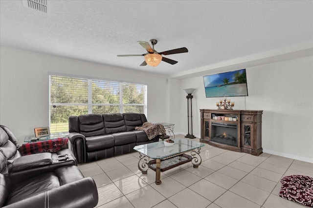 living room featuring light tile patterned floors, a textured ceiling, and ceiling fan