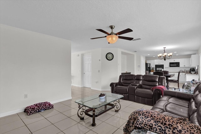 tiled living room with ceiling fan with notable chandelier and a textured ceiling