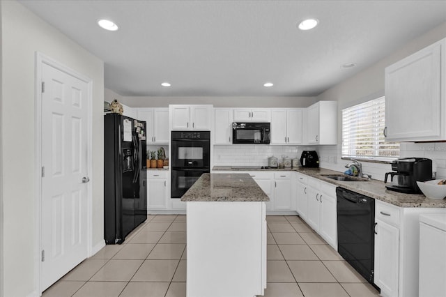 kitchen featuring a kitchen island, sink, white cabinets, black appliances, and light stone countertops