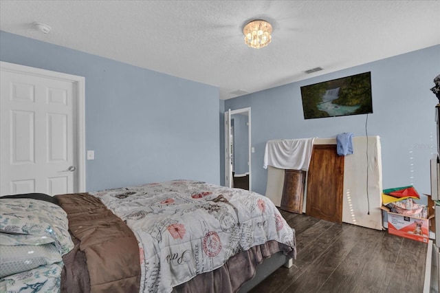 bedroom with dark wood-type flooring and a textured ceiling