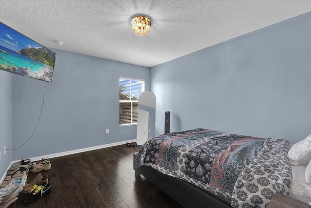 bedroom with dark wood-type flooring and a textured ceiling