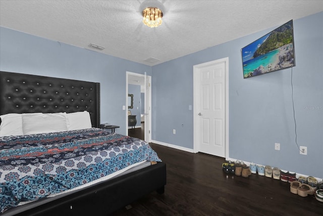 bedroom featuring a textured ceiling and dark hardwood / wood-style flooring