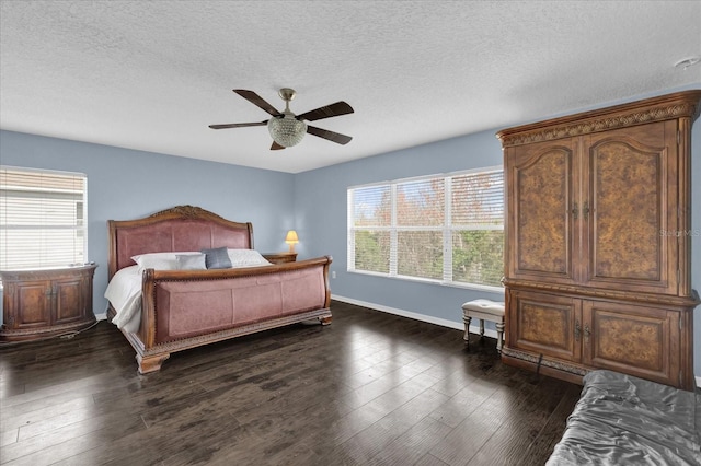 bedroom featuring ceiling fan, dark hardwood / wood-style flooring, and multiple windows