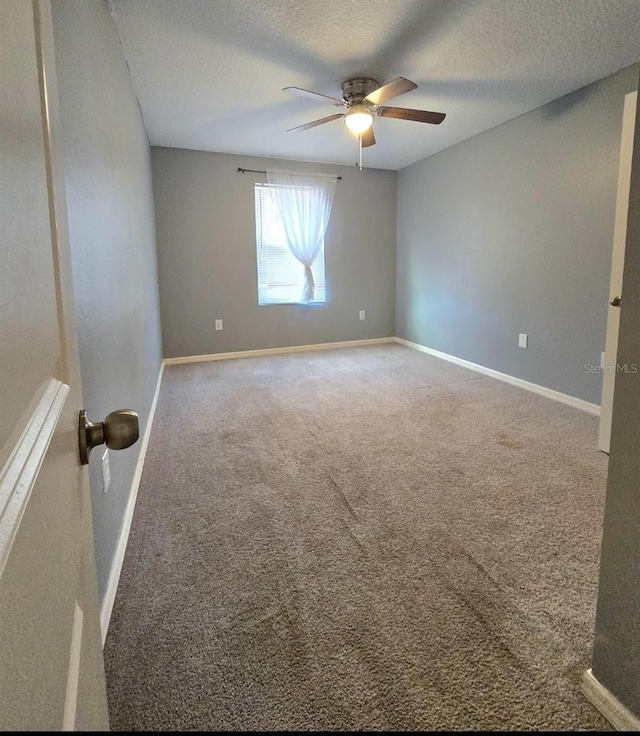 carpeted empty room featuring ceiling fan and a textured ceiling