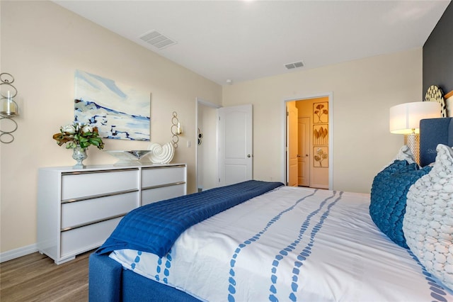 bedroom featuring ensuite bathroom and light wood-type flooring