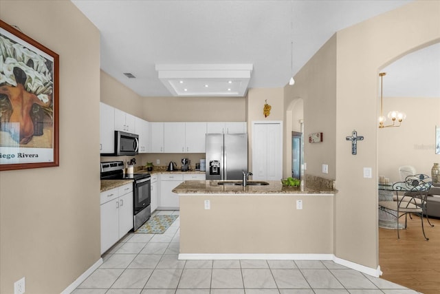 kitchen with pendant lighting, sink, white cabinets, and appliances with stainless steel finishes