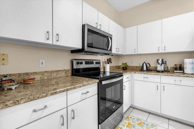 kitchen featuring white cabinetry, appliances with stainless steel finishes, light tile patterned floors, and light stone counters