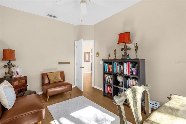 living area with dark hardwood / wood-style floors and ceiling fan