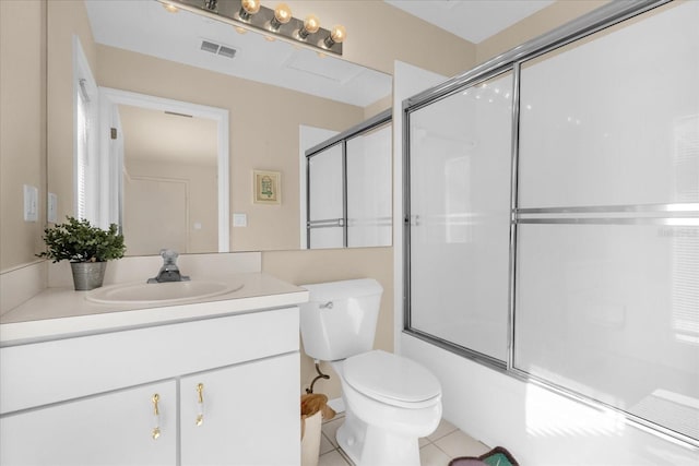 full bathroom featuring enclosed tub / shower combo, vanity, toilet, and tile patterned flooring