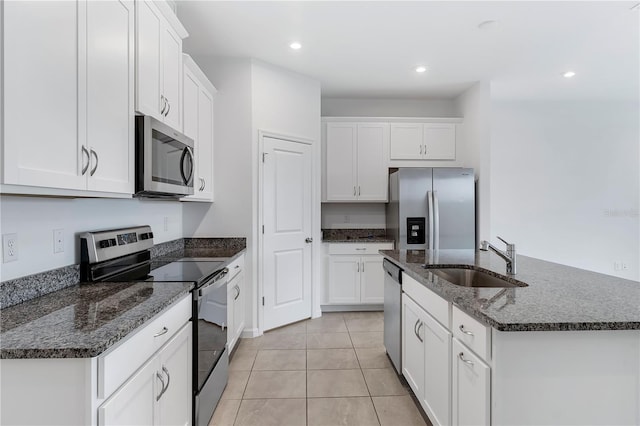 kitchen featuring appliances with stainless steel finishes, a kitchen island with sink, sink, and white cabinets