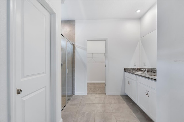 bathroom featuring tile patterned flooring, vanity, and a shower with shower door