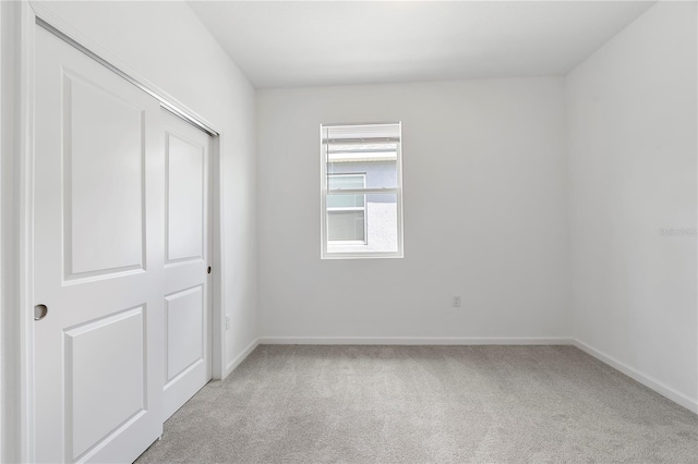 unfurnished room featuring light colored carpet