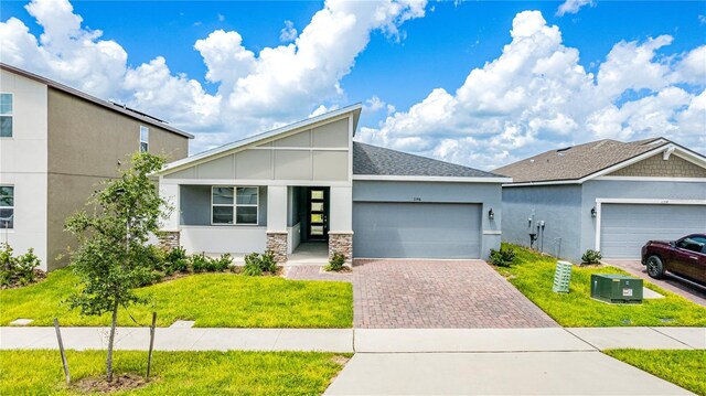 view of front of property with a garage and a front lawn