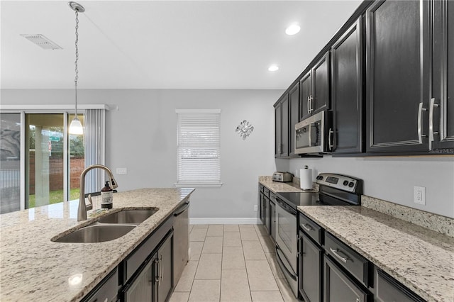 kitchen with pendant lighting, sink, light tile patterned floors, light stone counters, and stainless steel appliances