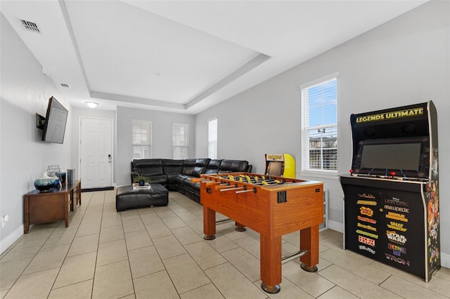 playroom featuring a tray ceiling, a wealth of natural light, and light tile patterned floors