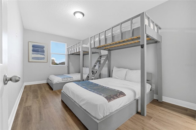 bedroom with wood-type flooring and a textured ceiling